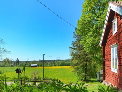 a field of yellow flowers next to a red building at 7 person holiday home in J RBO in Åshammar