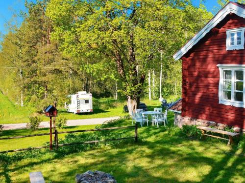 a red house with a table and chairs in a yard at 7 person holiday home in J RBO in Åshammar