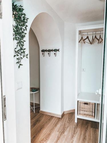 a room with white walls and a door with a plant at VillaMar Figueira da Foz in Figueira da Foz
