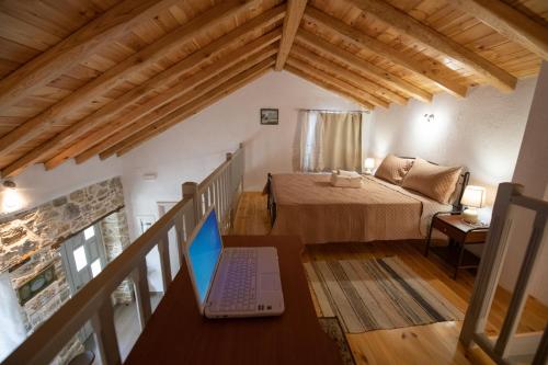 a bedroom with a laptop on a desk in a room at Oneiro Cottage in Skopelos Town
