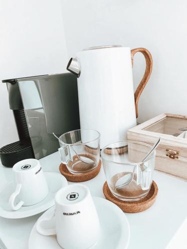 a counter with a coffee maker and two measuring cups at VillaMar Figueira da Foz in Figueira da Foz