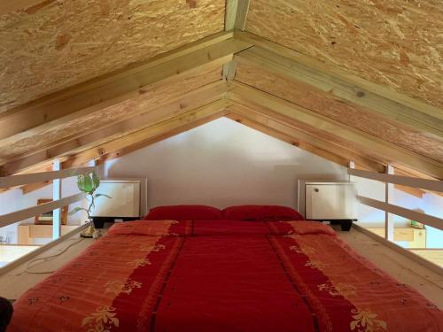 a bedroom with a large red bed with wooden ceilings at Apartment Sunny Place in Bihać