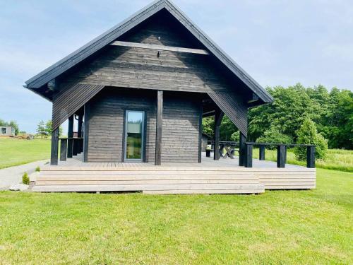 a small building with a porch on a grass field at Spithami Seaside Wooden Chalet in Spithami