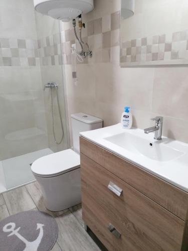 a bathroom with a toilet and a sink and a shower at Apartamentos Sane in Noja