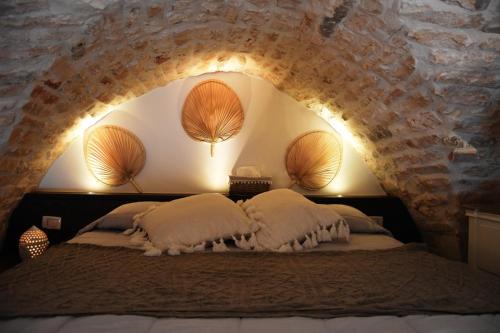 1 dormitorio con 1 cama en una pared de piedra en Alcova Cellini Bell'Italia, en Cisternino