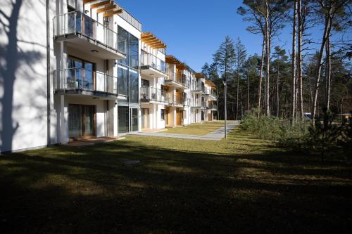 an apartment building with a lawn in front of it at Fabulous Apartments - Euronia in Pobierowo
