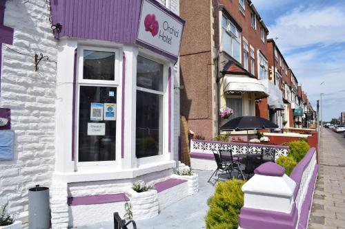 a purple and white building with a table in front of it at MyRoomz Orchid Hotel in Blackpool