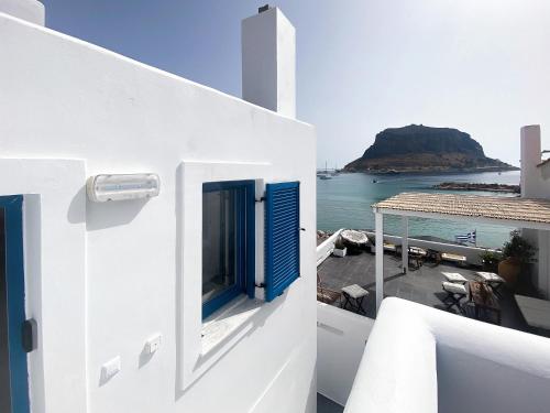 a white house with a blue door and the ocean at LULU - Self Catering Accommodation in Monemvasia