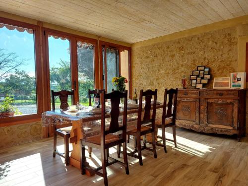 a dining room with a table and chairs and windows at Gite La Saubolle à Marciac in Marciac