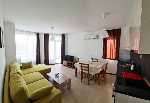 a living room with a yellow couch and a table at Aquamarine Apartments in Sveti Vlas