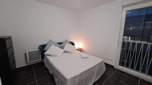 um pequeno quarto com uma cama e uma janela em Appartement Plage Prado/Vélodrome em Marselha