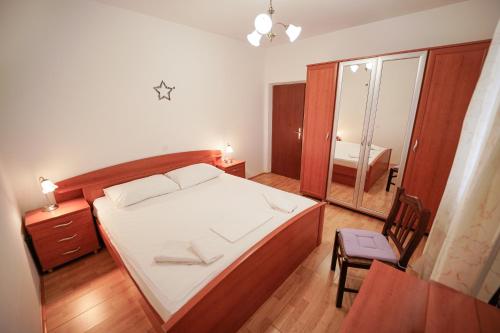 a bedroom with a bed and a chair and a mirror at House Relax in Selca