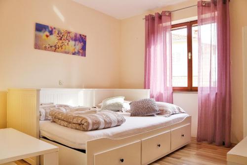 a bed in a room with pink curtains at Studio Airport Dubrovnik in Čilipi