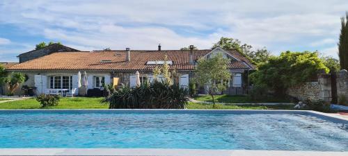 une maison avec une piscine devant une maison dans l'établissement Domaine des Prés de Joussac - Protocole sanitaire strict, à Jau-Dignac-et-Loirac