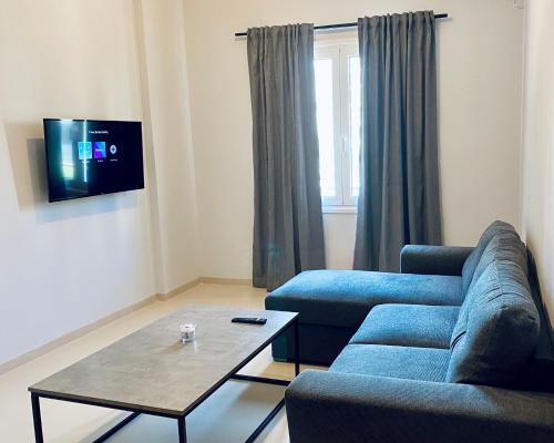 a living room with a blue couch and a coffee table at Omega54 City Suites Athens Central Business District in Athens