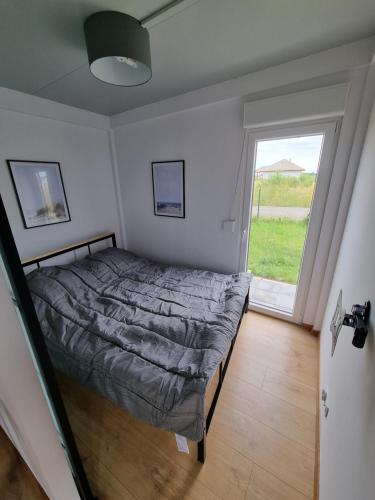 a bedroom with a bed and a large window at Gąski domek 800m od morza in Gąski
