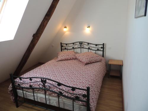 a bedroom with a black bed in a attic at Le Village du Phare in Gouville-sur-Mer