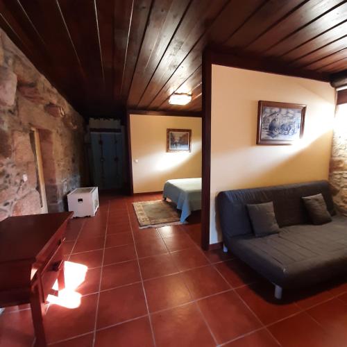 a living room with a couch and a bed at Quinta do Real - Casa de Campo in Viana do Castelo