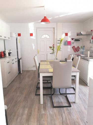 une cuisine et une salle à manger avec une table et des chaises dans l'établissement Charmant logis dans une construction de caractère, à Gérardmer