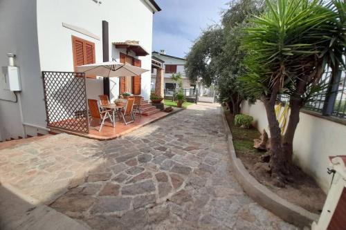 a patio with a table and an umbrella next to a house at Dolce casa spiaggia&relax in Lotzorai
