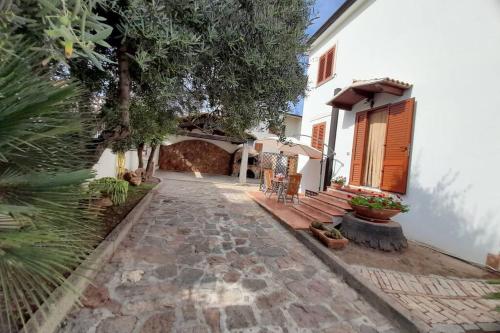 a courtyard of a house with a stone walkway at Dolce casa spiaggia&relax in Lotzorai
