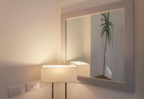 a light in a room with a mirror and a lamp at Residenza I Melograni - Suite in Domaso