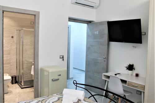 a room with a bed and a desk and a television at Sea Garden Rooms in Termoli