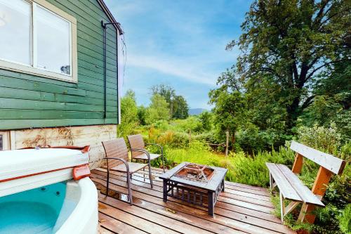 una terraza con bañera de hidromasaje y sillas en una casa en River View House, en Springfield