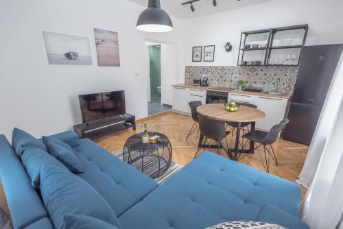 a living room with a blue couch and a table at Vila Pobeda in Banja Koviljača