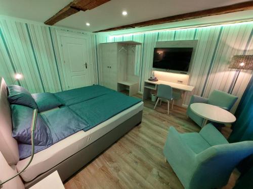 a bedroom with a bed and a desk and chairs at AnaCapri Gästehaus Le Havre in Ueckermünde