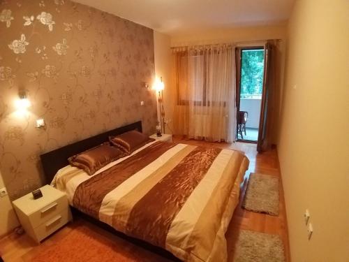a bedroom with a large bed and a window at Brown Apartment - Niš Center in Niš