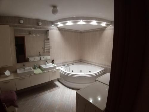 a large bathroom with a tub and two sinks at Brown Apartment - Niš Center in Niš