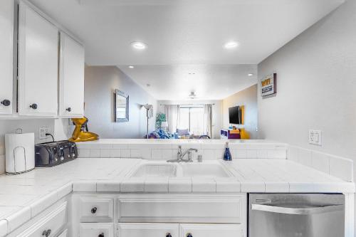 a white kitchen with a sink and a counter at Red Roof Retreat in Rancho Mirage