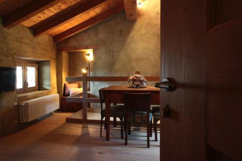 Habitación con mesa y dormitorio con cama. en Borgo Selvapiana en Morbegno