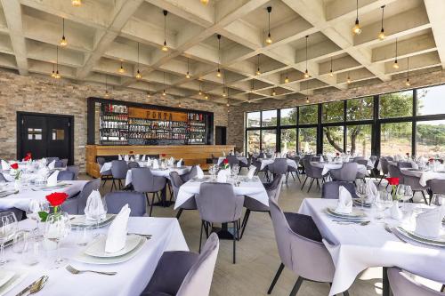 una sala da pranzo con tavoli e sedie bianchi di Dulamerovic Resort a Bar