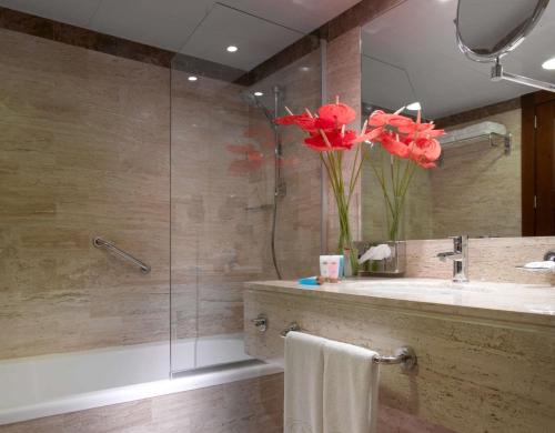 a bathroom with a sink and a shower with red flowers at Grand Palladium Vallarta Resort & Spa - All Inclusive in Punta Mita