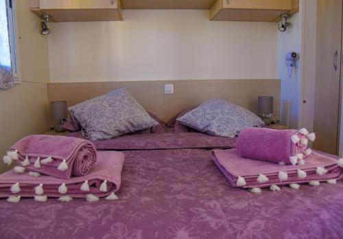 um quarto com 2 camas com cobertores e almofadas cor-de-rosa em House Matea em Bilice
