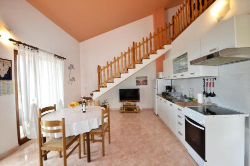 eine Küche und ein Esszimmer mit einem Tisch und Stühlen in der Unterkunft Apartments Ella in Poreč