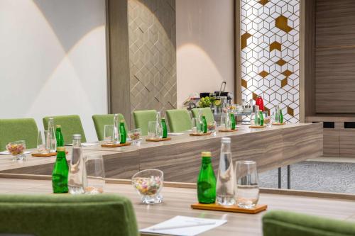 a row of tables with green chairs and bottles at Park Inn by Radisson, Riyadh in Riyadh