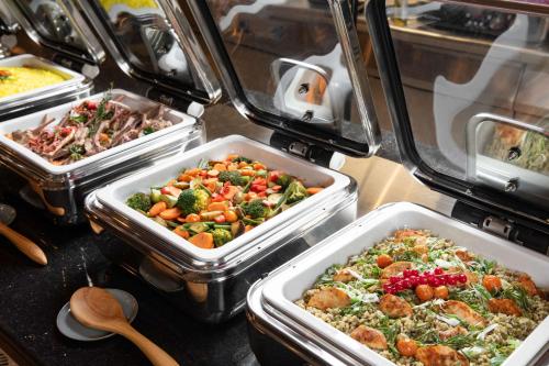 a buffet with several trays of food on a table at Park Inn by Radisson, Riyadh in Riyadh