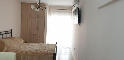 a bedroom with a bed and a large window at Loutraki Vibes Apartments 2 in Loutraki