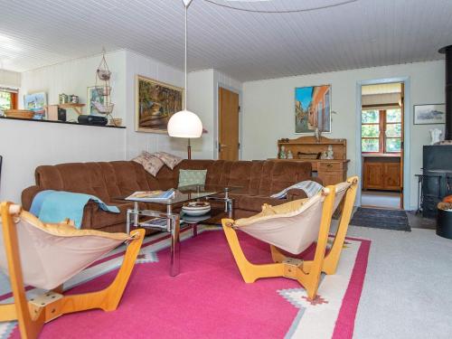 uma sala de estar com um sofá, uma mesa e cadeiras em 6 person holiday home in H jslev em Bøstrup