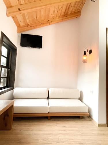 a living room with a white couch and a tv at Amalia Hotel in Berat