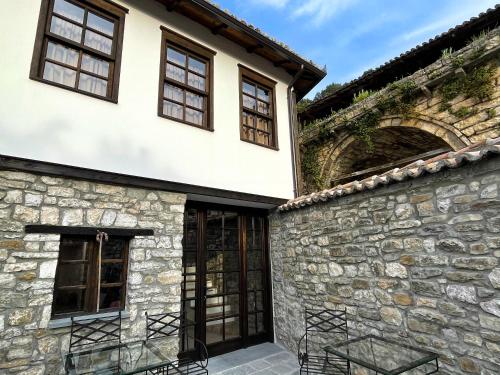 an exterior view of a building with windows and a stone wall at Amalia Hotel in Berat