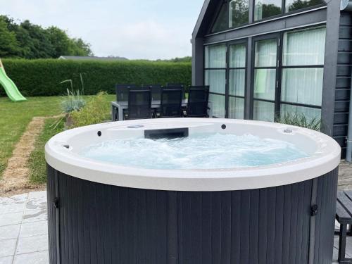 12 person holiday home in Hadsund في Nørre Hurup: حوض استحمام ساخن في الحديقة الخلفية للمنزل