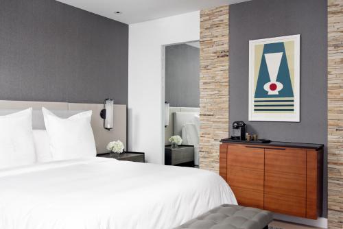 a bedroom with a white bed and a dresser at Four Seasons Hotel Denver in Denver