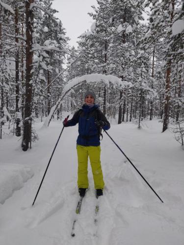 a woman is standing on skis in the snow at Peace & Quiet Hotel in Jokkmokk