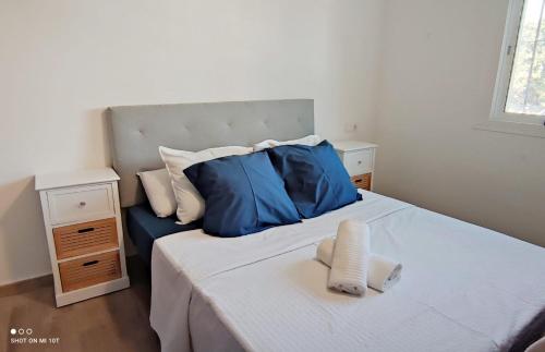um quarto com uma cama grande e almofadas azuis em Chalet privado buenas noches em Estepona