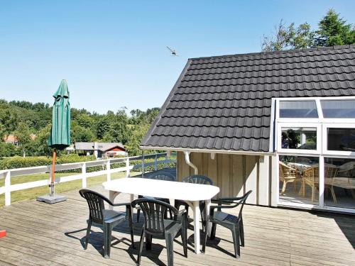 einen Tisch und Stühle auf einer Terrasse mit einem Sonnenschirm in der Unterkunft 8 person holiday home in Sp ttrup in Lihme
