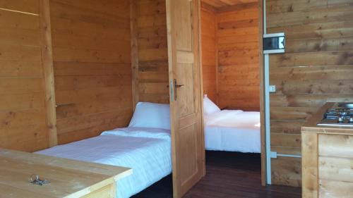 a room with two beds in a wooden cabin at Agricampeggio Madonna di Pogi in Bucine
